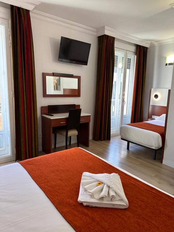 A bed or beds in a room at Hostal Abadia Madrid