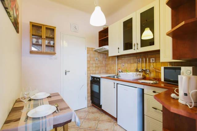 ブダペストにあるComedy Apartmentのキッチン(白いキャビネット、カウンタートップ付)