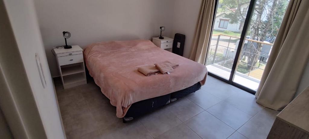 Habitación pequeña con cama y ventana en Villa General Belgrano Inbalo 01 en Villa General Belgrano