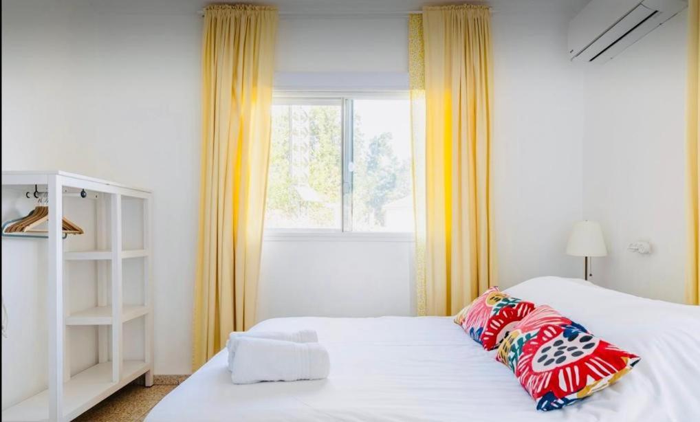 a bedroom with a white bed and a window at Hollyday & vacation in Beit Hillel