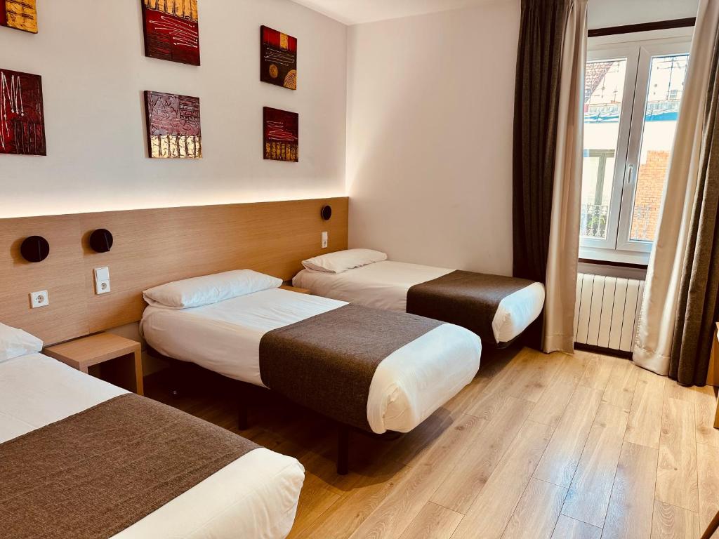 A bed or beds in a room at Hostal Abadia Madrid