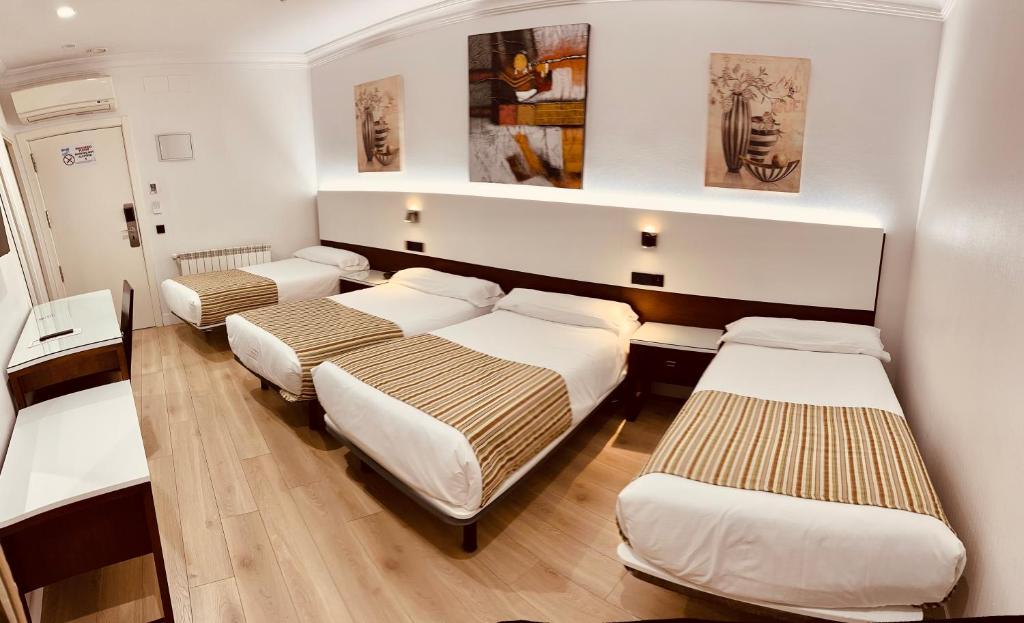 A bed or beds in a room at Hostal Abadia Madrid