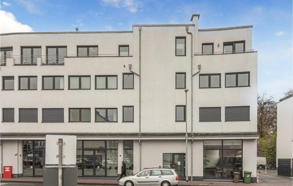 un edificio blanco con un coche aparcado delante de él en Amazing Apartment In Hilden With Kitchen, en Hilden