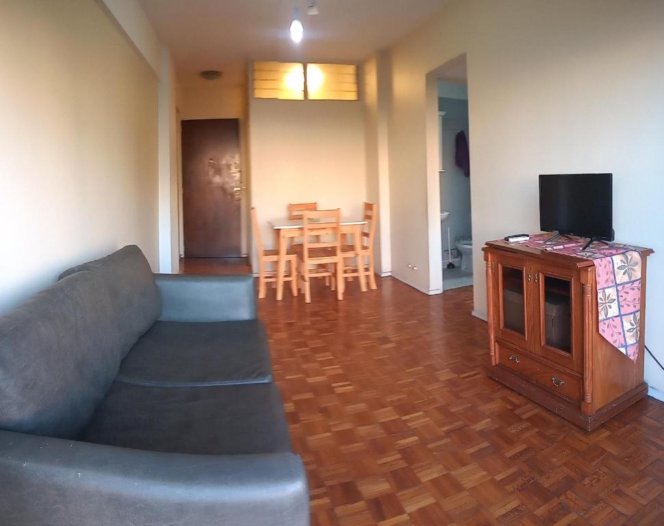Sala de estar con sofá, TV y mesa en METROBUS OBELISCO blue venta en Buenos Aires