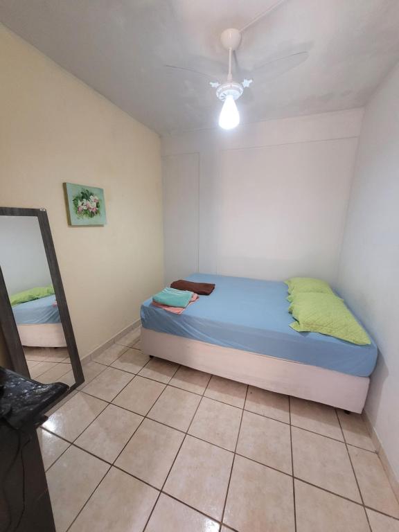 Dormitorio pequeño con cama y espejo en Linda Kitnet Mobiliada Mar Itapua, en Vila Velha