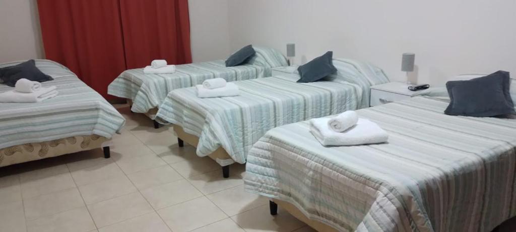Habitación de hotel con 3 camas y toallas. en Lo de Chavela en Salta