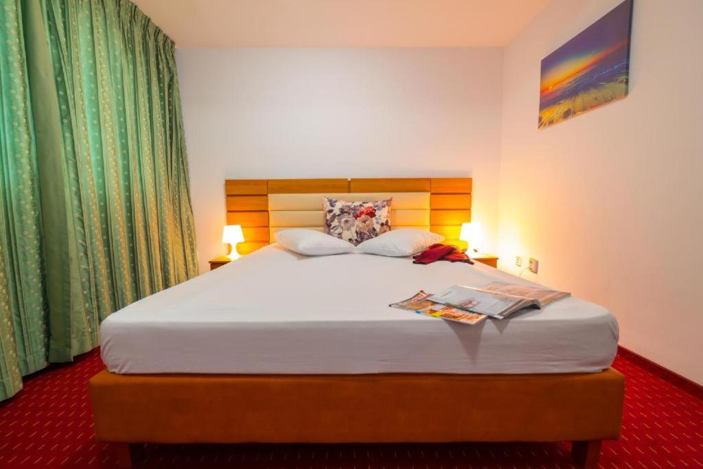 Un pat sau paturi într-o cameră la Hotel Sir Orhideea
