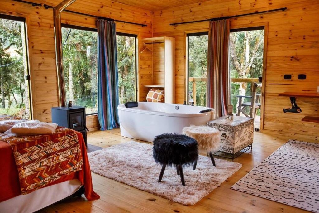 una sala de estar con bañera en una cabaña en Cabanas Cambuim - Urubici - SC, en Urubici
