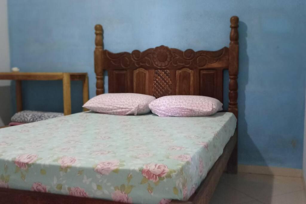 Una cama con dos almohadas rosas encima. en casa bela vista, en Milho Verde