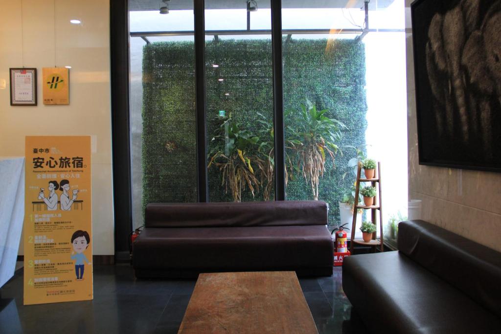 a waiting room with a leather couch and a table at The Galerie Hotel in Taichung