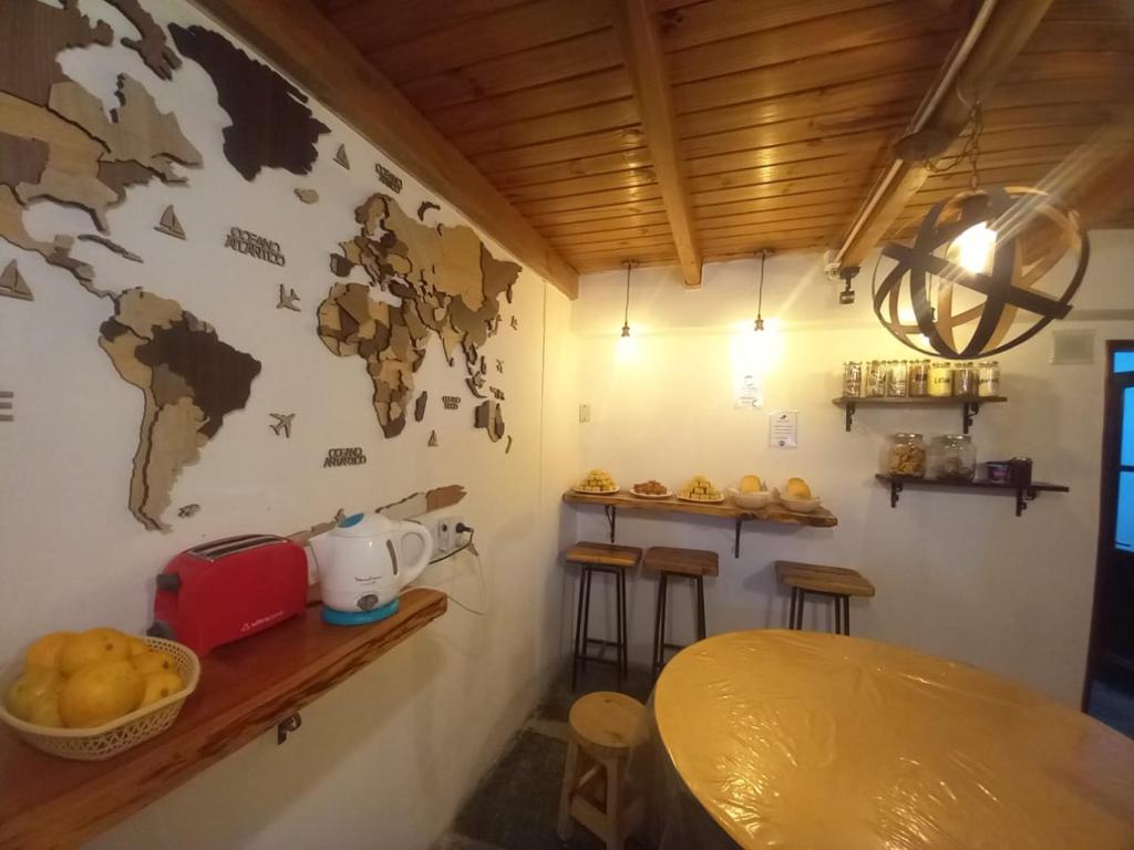 a room with a table and a map on the wall at Hostel Piltri in El Bolsón