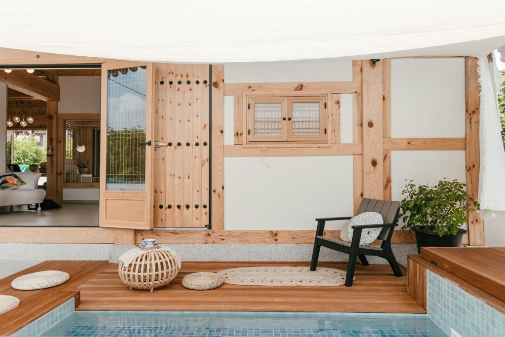 een huis met een zwembad en een stoel op een veranda bij Gyeongju Hanok Sohwa in Gyeongju