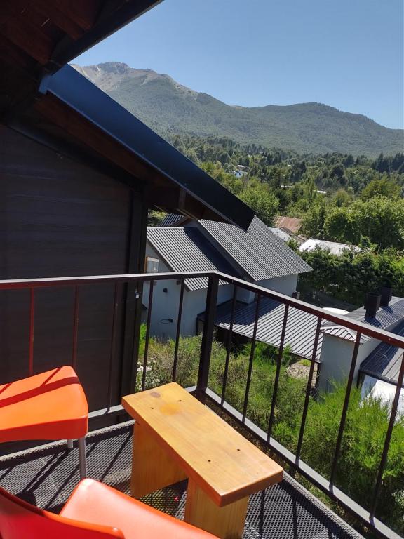 balcón con mesa, sillas y montañas en ALOJAMIENTOS PATAGONICOSEl Estudio VLA en Villa La Angostura