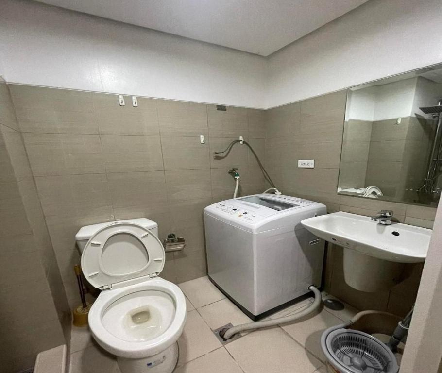 a small bathroom with a toilet and a sink at Shore Residences in Manila