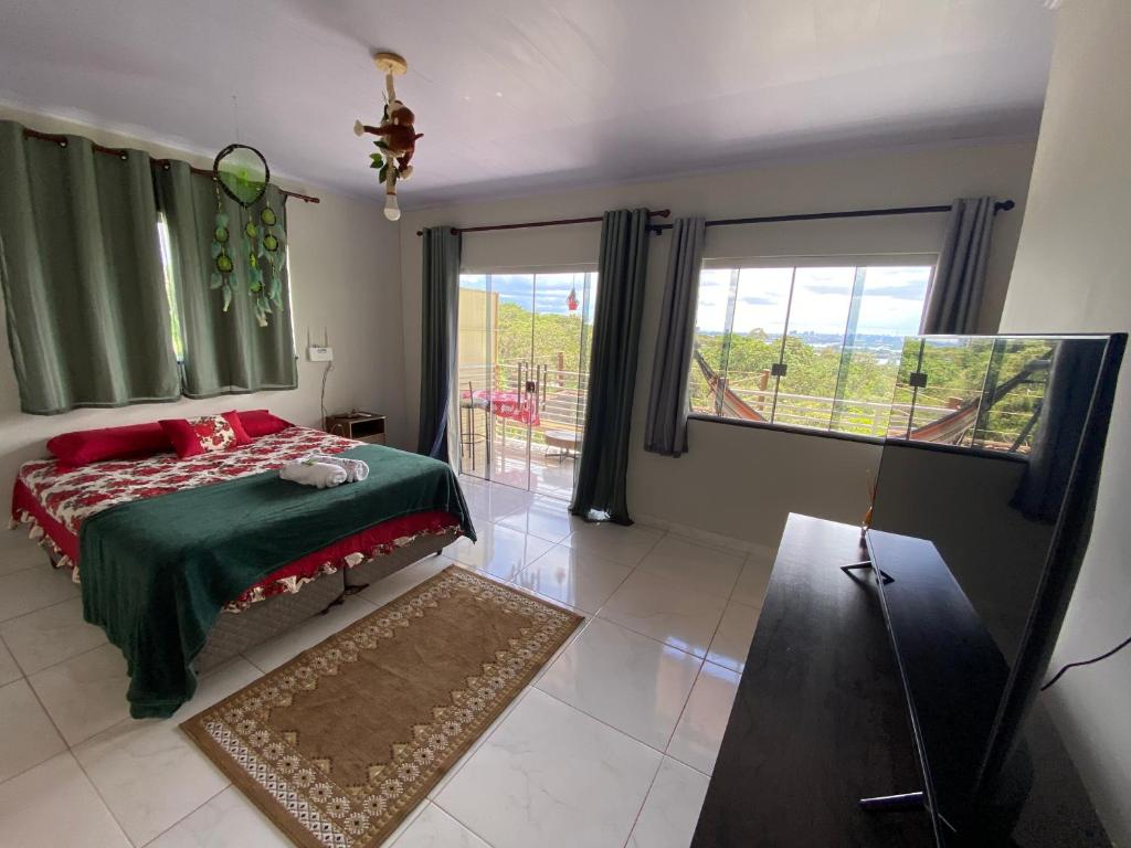 Un dormitorio con una cama con almohadas rojas y una ventana en Sunshine Chalé Brasília-DF en Brasilia