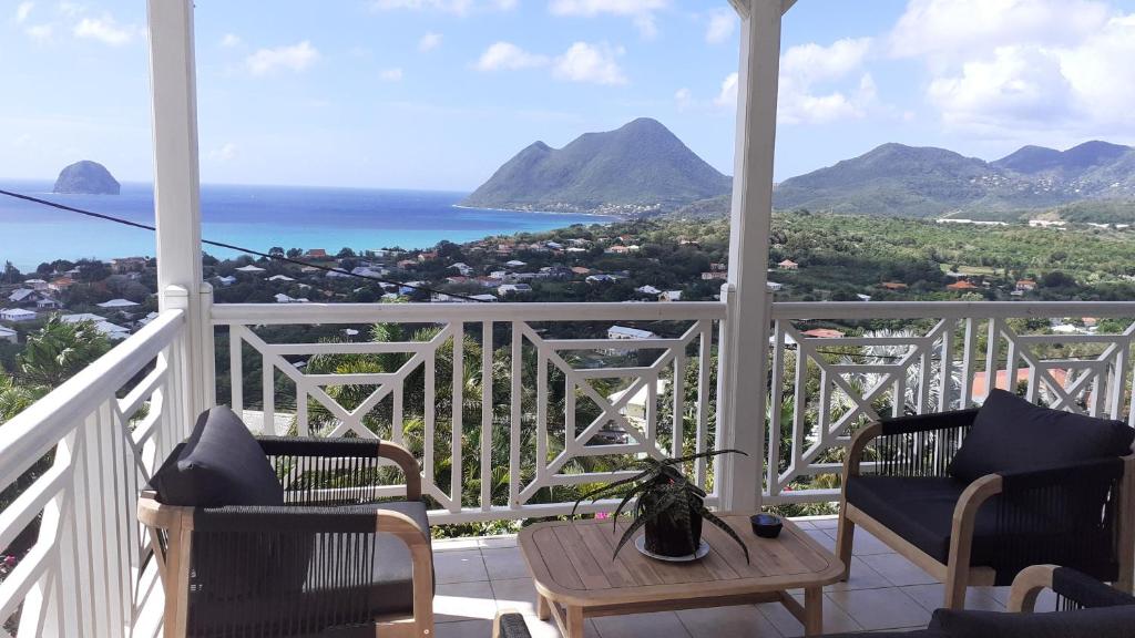 a balcony with a view of the ocean and mountains at VILLA KARAT in Le Diamant