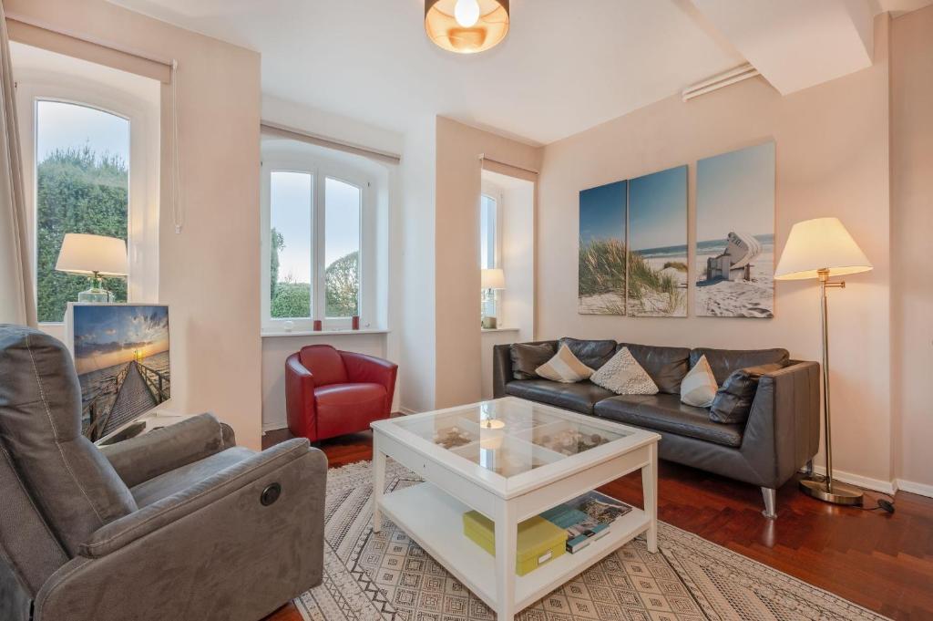 a living room with two couches and a coffee table at Villa Meereswoge - Goldstern in Bansin