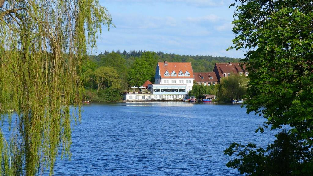 a large building sitting on top of a large lake at Restaurant und Hotel Zum Weissen Ross in Mölln
