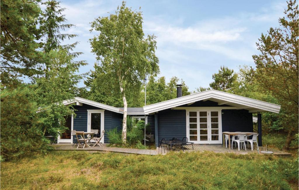 a blue house with a deck and a table at Holiday Home H in Højby
