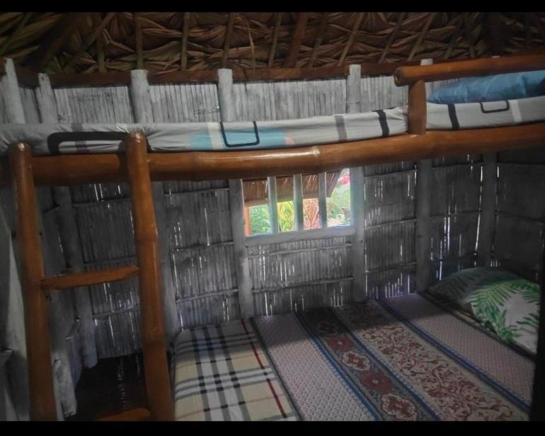 two bunk beds in a hut with a window at Close Kubo 
