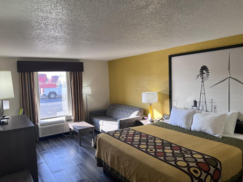a hotel room with a bed and a couch at Super 8 by Wyndham Ft Stockton in Fort Stockton