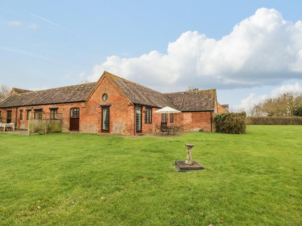 an old brick house with a green yard at Condicote Cottage in Weston on Avon