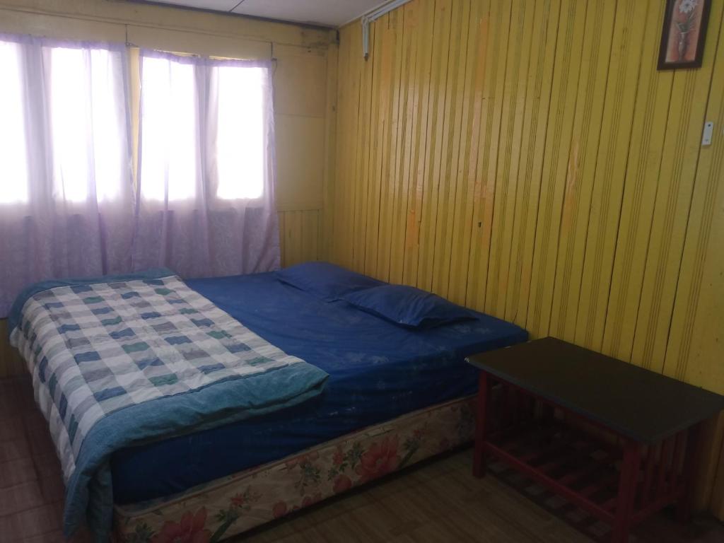 Dormitorio pequeño con cama y mesa en Barokah Homestay en Bachok