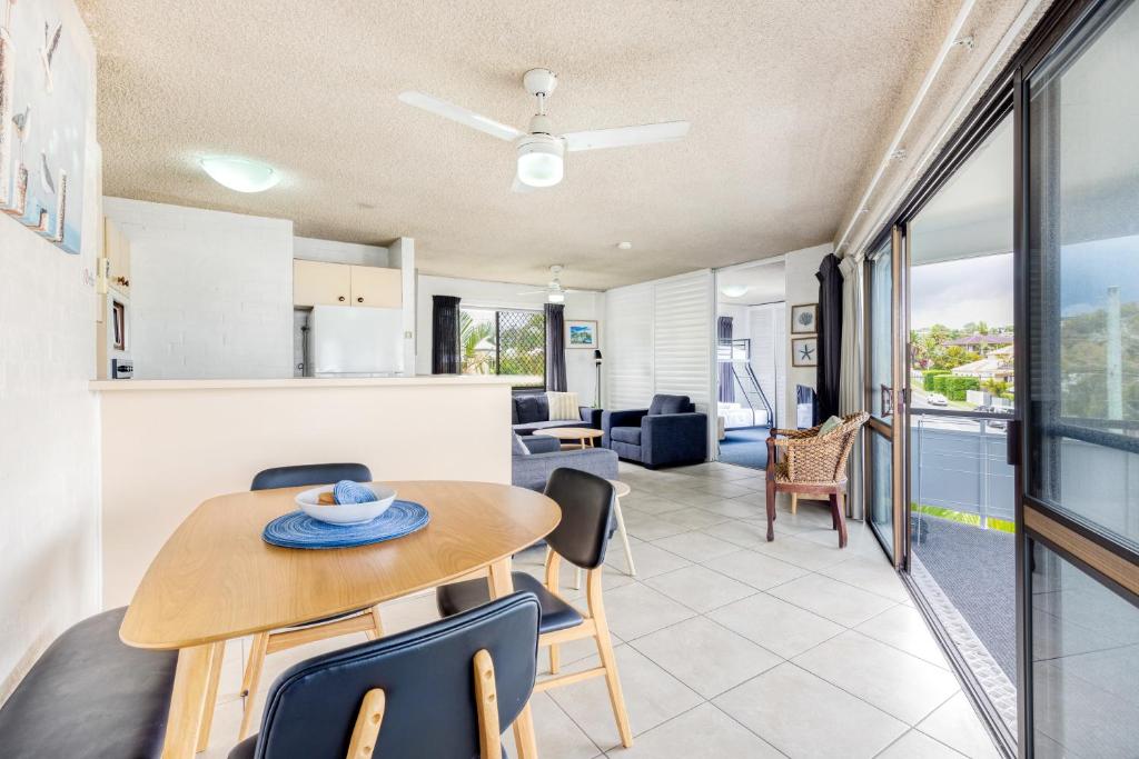 a dining room and living room with a table and chairs at Tindarra Apartments in Alexandra Headland