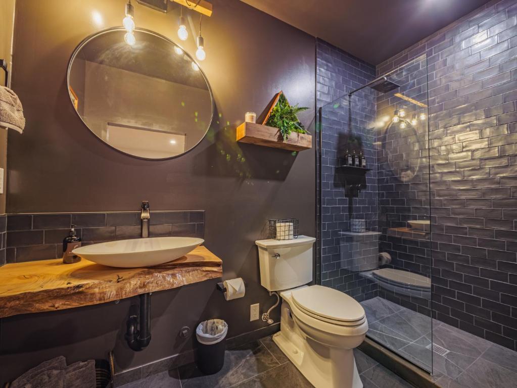 een badkamer met een wastafel, een toilet en een douche bij Winter's Hideaway Suite in Ucluelet
