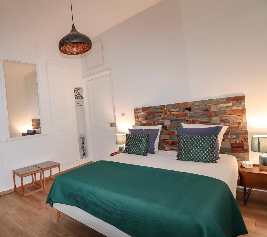 a bedroom with a large bed with a brick wall at Ginkgo Maison d'hôtes in Amiens