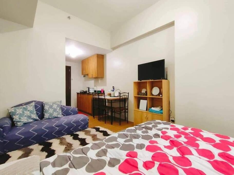 una sala de estar con una cama y un sofá en CityView Condo with balcony-12, en Cagayan de Oro
