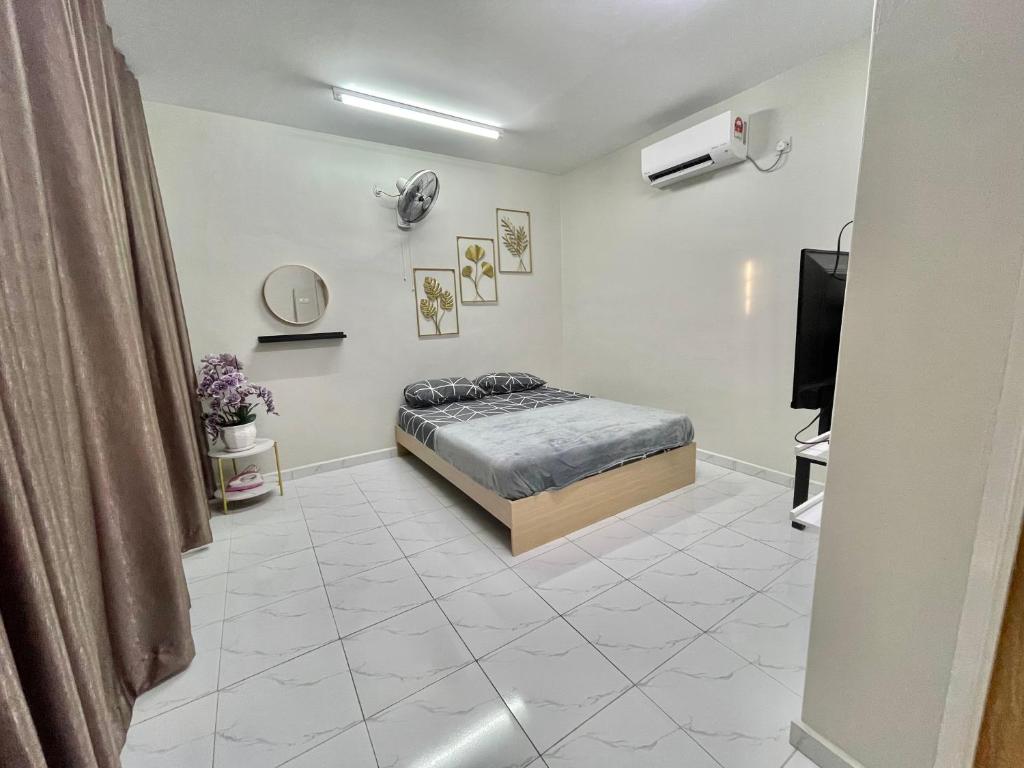 Aufa Roomstay في Pendang: غرفة نوم فيها سرير وتلفزيون
