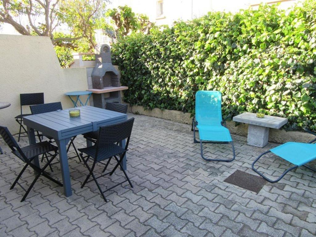 d'une terrasse avec une table et des chaises bleues. dans l'établissement Appartement climatisé avec grande terrasse, proche plages et équipé pour 5 personnes - FR-1-326-657, à Marseillan