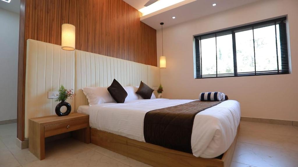 una camera con un grande letto e una finestra di Alleppey Haven Beach Villa a Alleppey