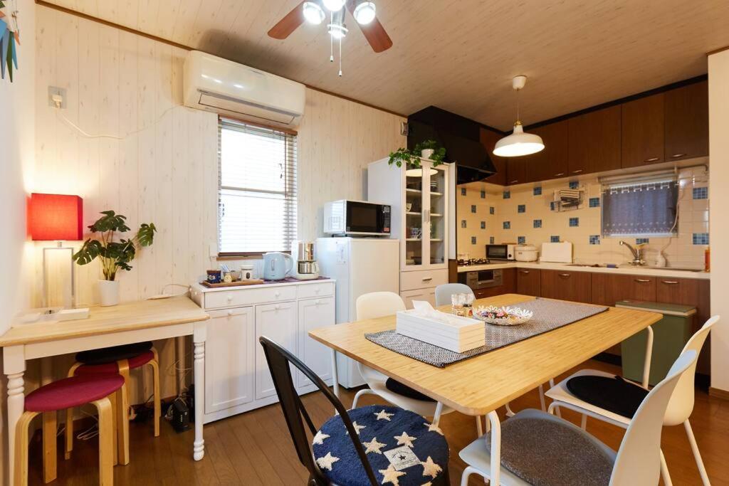 uma cozinha com mesa e cadeiras e uma cozinha com geladeira em Seaside House Enoshima 江ノ島, Free Parking 漫居湘南海岸, 尋訪灌籃高手 em Koshigoe