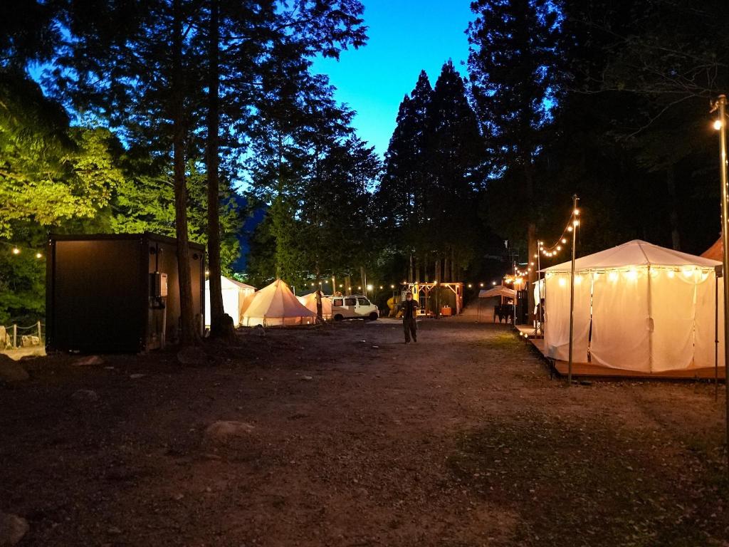 - un groupe de tentes dans un parc la nuit dans l'établissement リバーサイドグランピングNuts, à Higashiomi