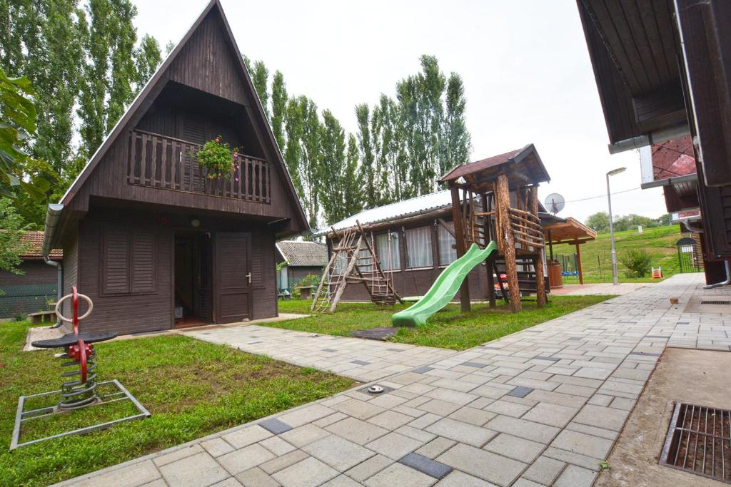 um parque infantil com um escorrega e uma estrutura de jogos em Tölgyes Üdülő em Doboz