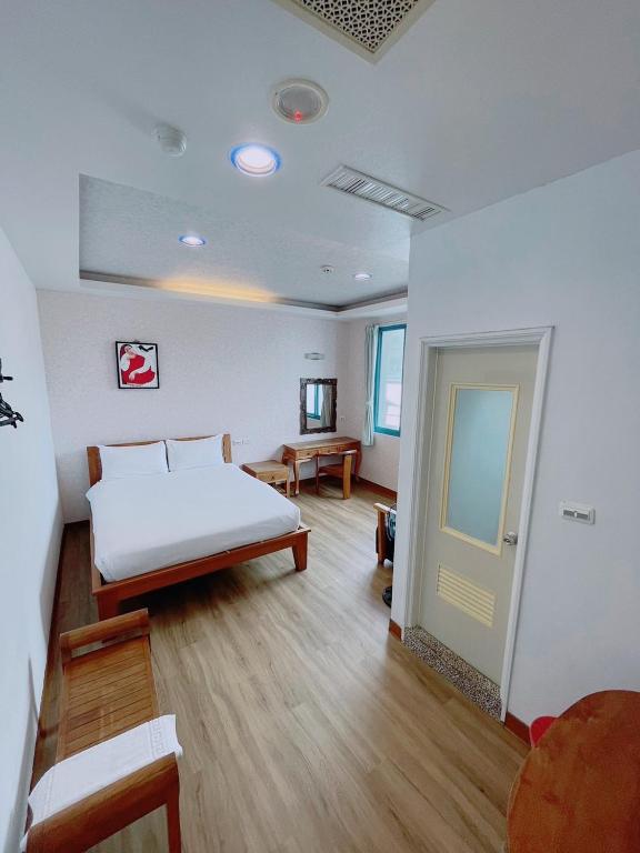 a bedroom with a bed and a table and a door at Blue Sea Inn in Eluan