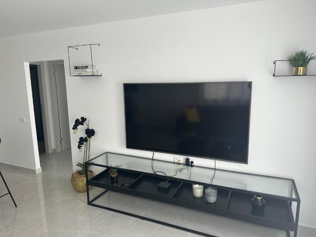 a living room with a large television on a wall at מישל נופש ,צופית תחתית 6003 in Eilat