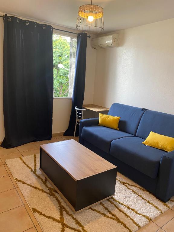 een woonkamer met een blauwe bank en een salontafel bij Le Studio Cosy II - Sainte Clotilde in Saint-Denis