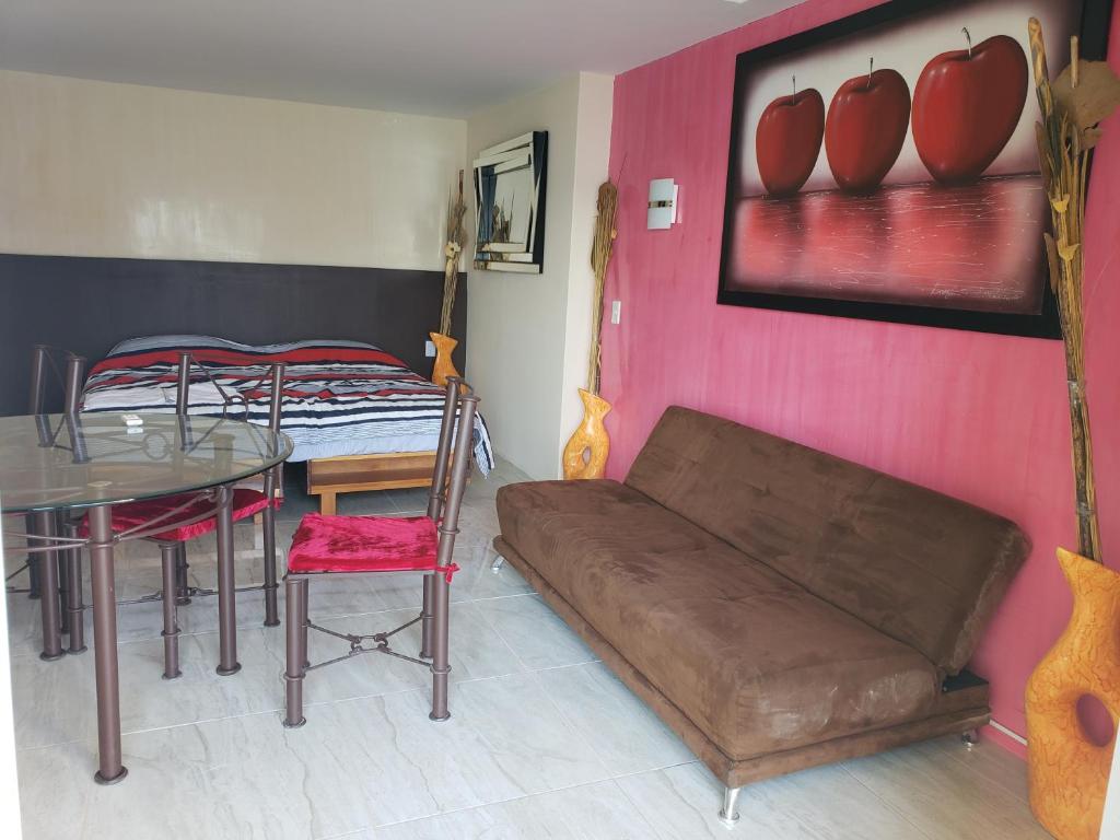 Hotel Torres Gemelas vista al mar a pie de playa في أكابولكو: غرفة معيشة مع أريكة وطاولة