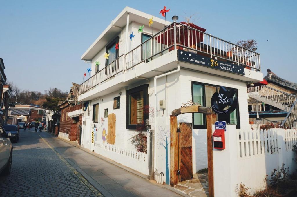 - un bâtiment blanc avec un balcon dans une rue dans l'établissement Byeolha Guesthouse, à Jeonju