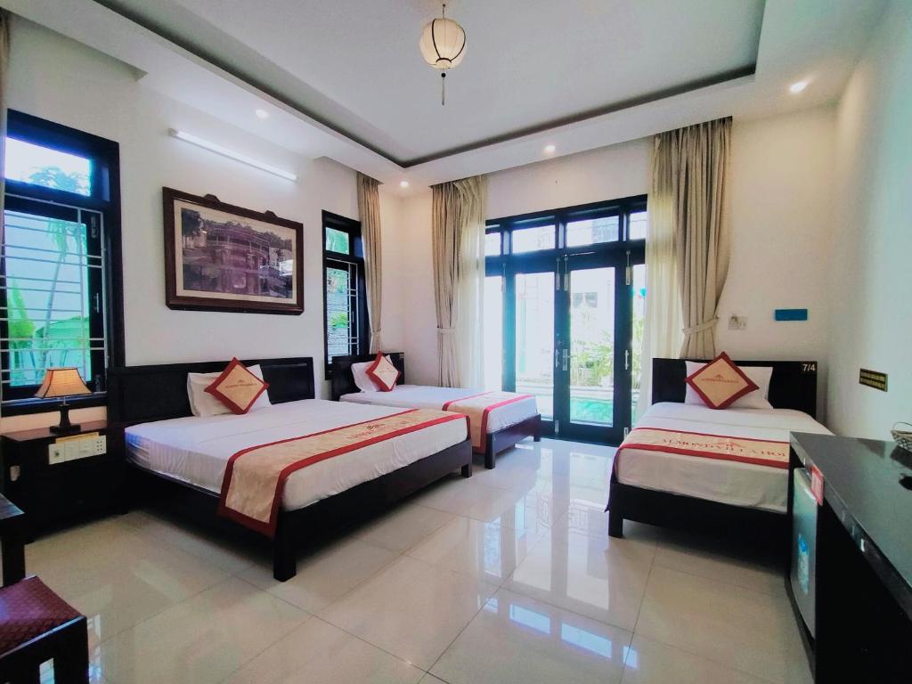 Postel nebo postele na pokoji v ubytování Almond Villa Hoi An