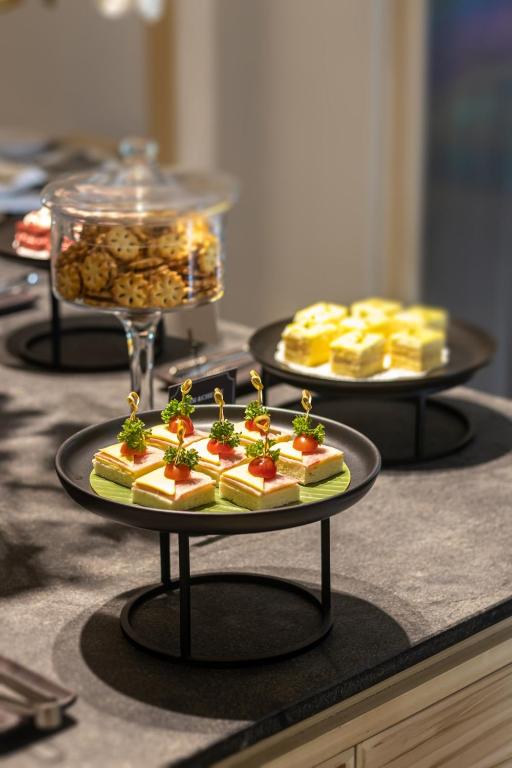 A close-up of small decorated pastries and cakes on a breakfast buffet.