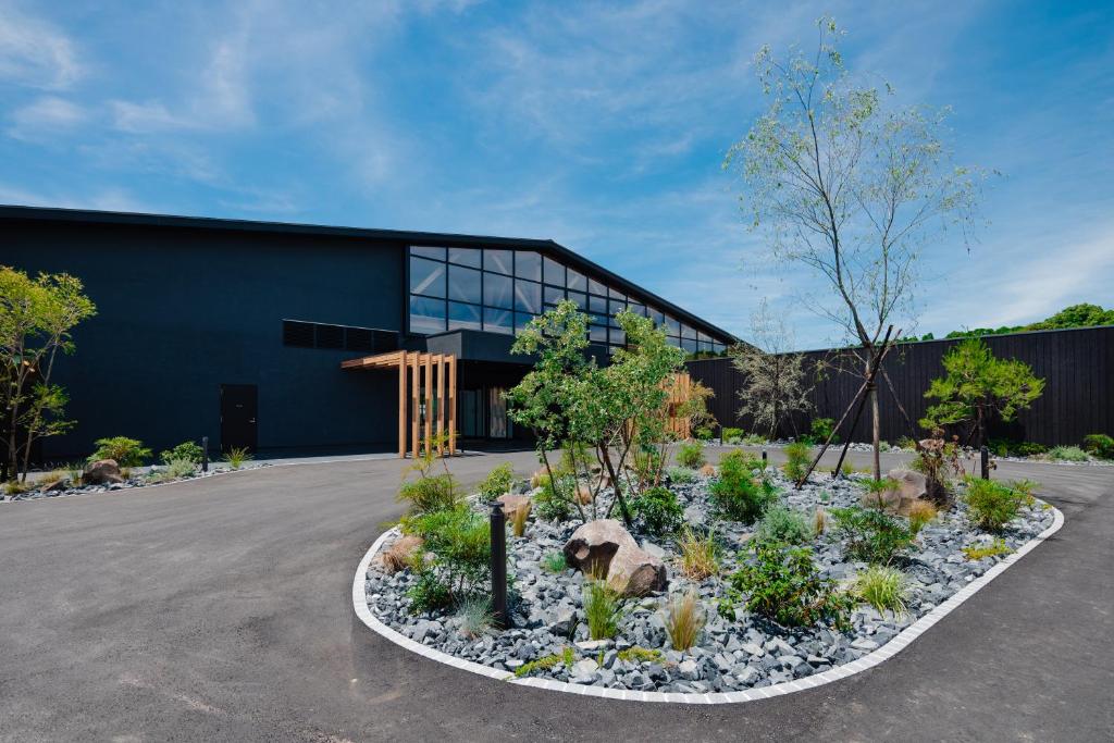 a building with a garden in front of a building at ISUMI Glamping Resort ＆Spa SOLAS in Isumi