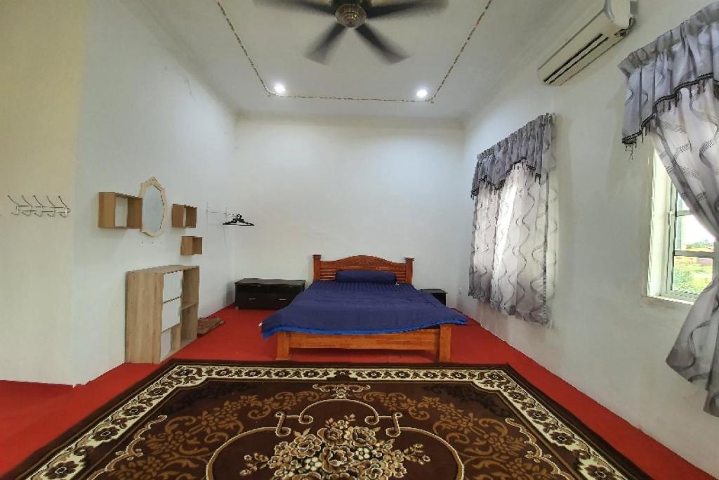 - une chambre avec un lit et un ventilateur de plafond dans l'établissement OYO Home 90723 Green Leaf Guest Lodge Kk, à Kota Kinabalu