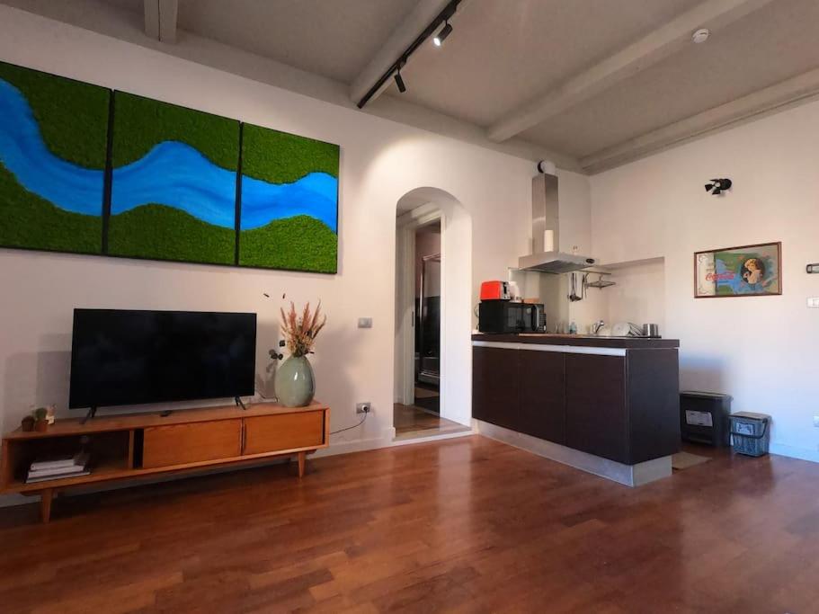 a living room with a flat screen tv and a kitchen at Mount Flower Trastevere Apt in Rome