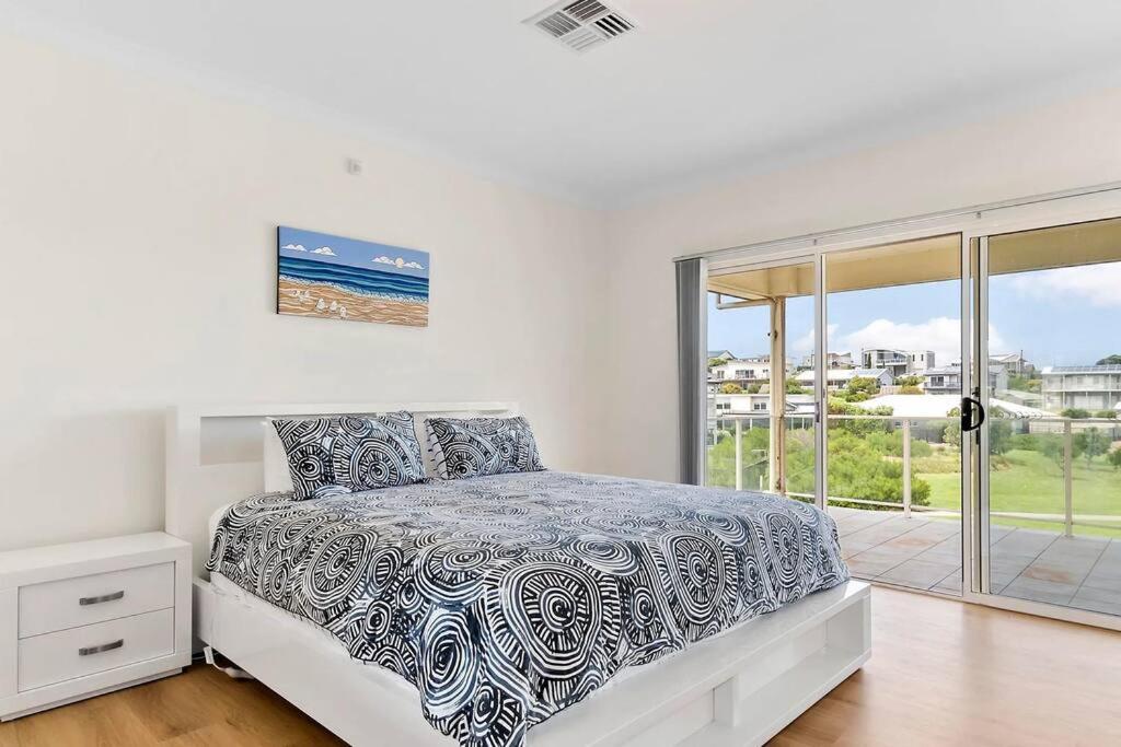 a bedroom with a bed and a large window at The Beach House in Middleton