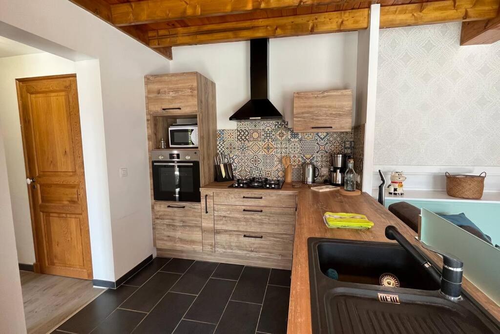 a kitchen with a sink and a stove top oven at La Reinette du Verger 9 d&#39;Arry 1 in Arry