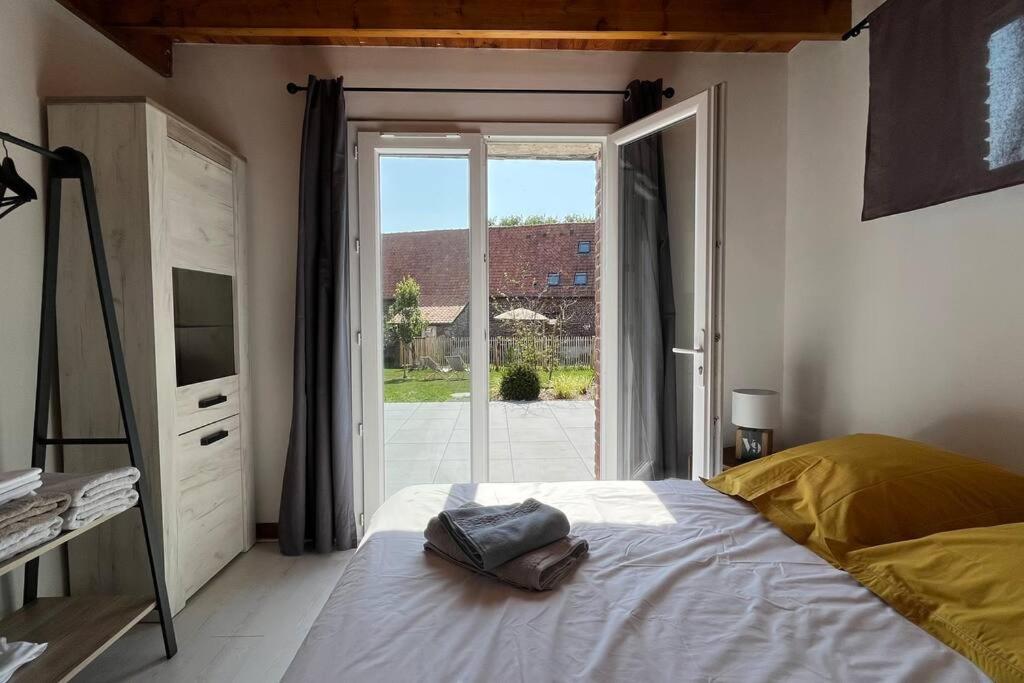 a bedroom with a bed and a large window at La Reinette du Verger 9 d&#39;Arry 1 in Arry